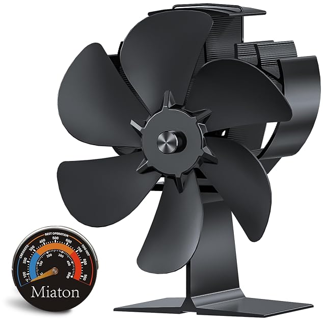 Ventilatore per stufa Miaton nero anodizzato, con sei pale inclinate, accanto a un termometro da stufa magnetico e tondo